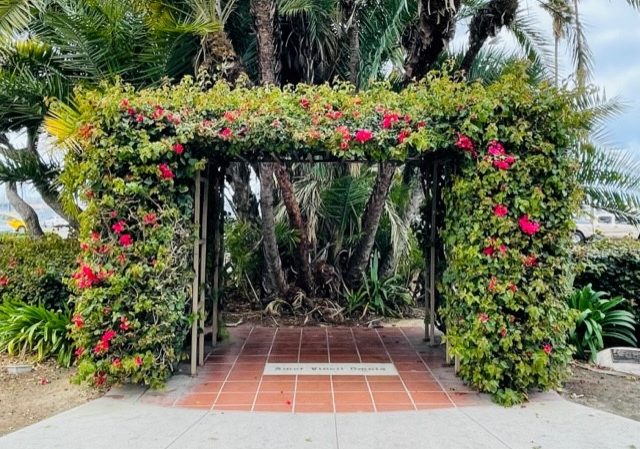 CAC West ceremony arbor with greenery and flowers