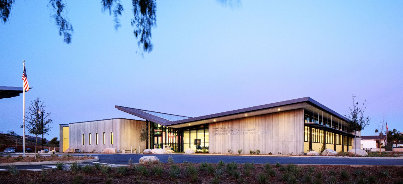 Image of wedding ceremony with guests on the side of the aisle, two people getting married and an officiant.