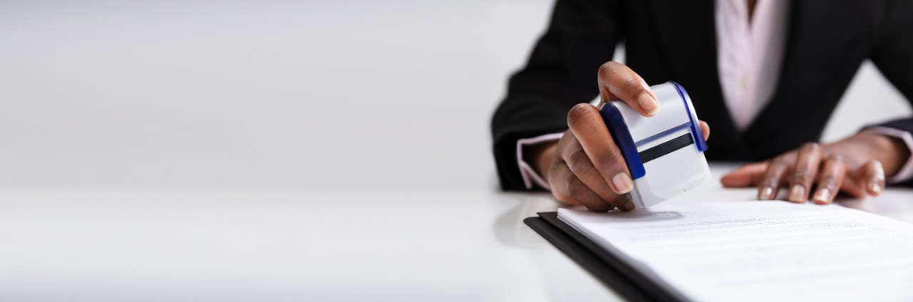 Image of a person stamping a document